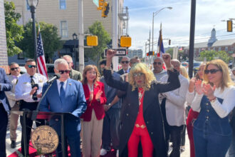 Fefita La Grande junto al letrero Fefita La Grande Way en Union City Nueva Jersey