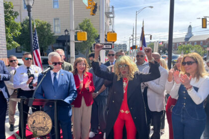Fefita La Grande junto al letrero Fefita La Grande Way en Union City Nueva Jersey